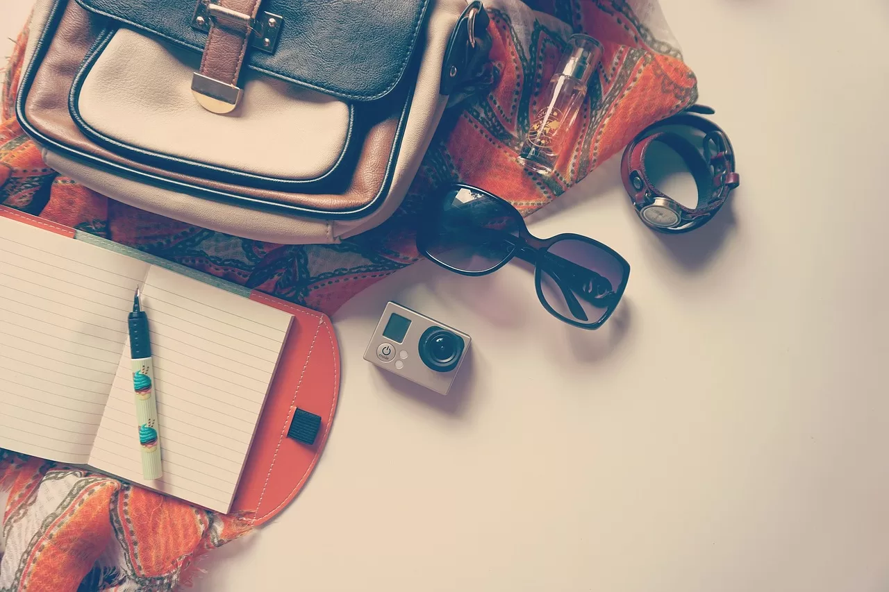 a suitcase, sunglasses, camera and other holiday items